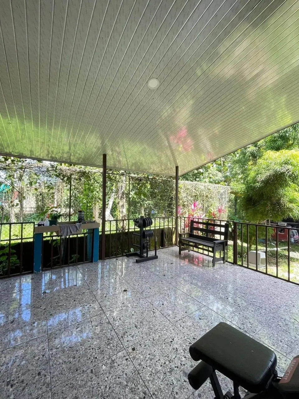 Terraza techada con baranda y vista al jardín