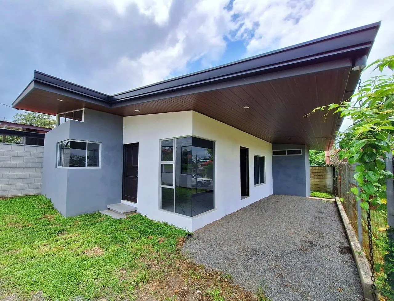 Casa nueva blanca y gris con alero de madera y ventanal de esquina