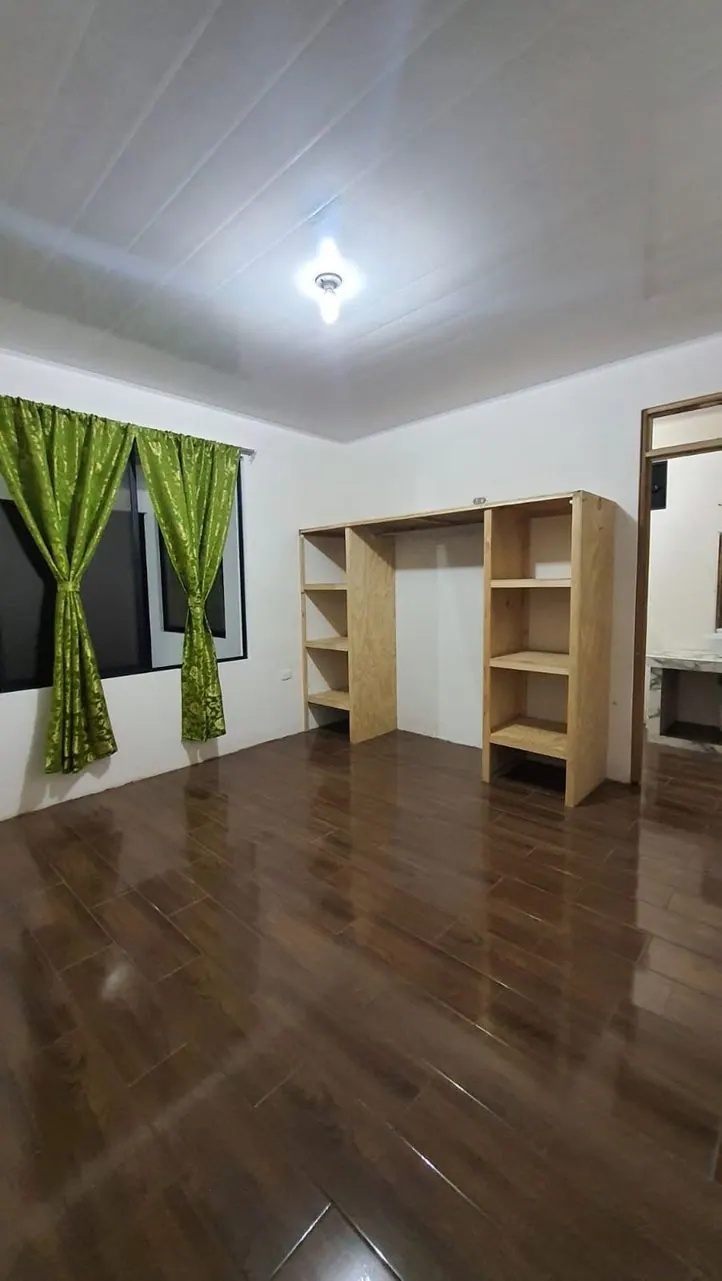 Habitación con cortinas verdes y clóset abierto