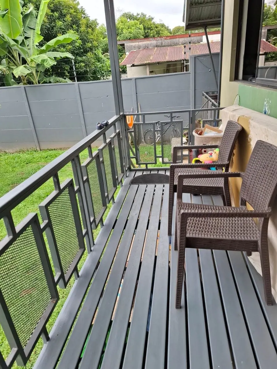 Terraza de madera con sillas y baranda
