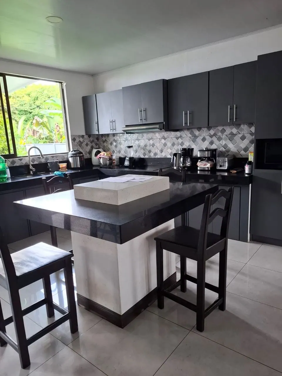Cocina con isla negra y muebles gris oscuro