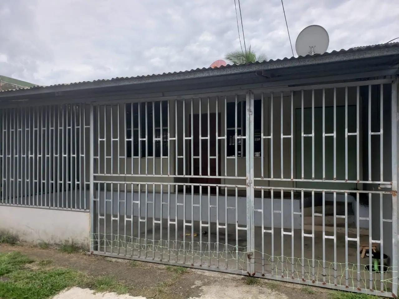 Casa gris con verjas blancas en toda la fachada