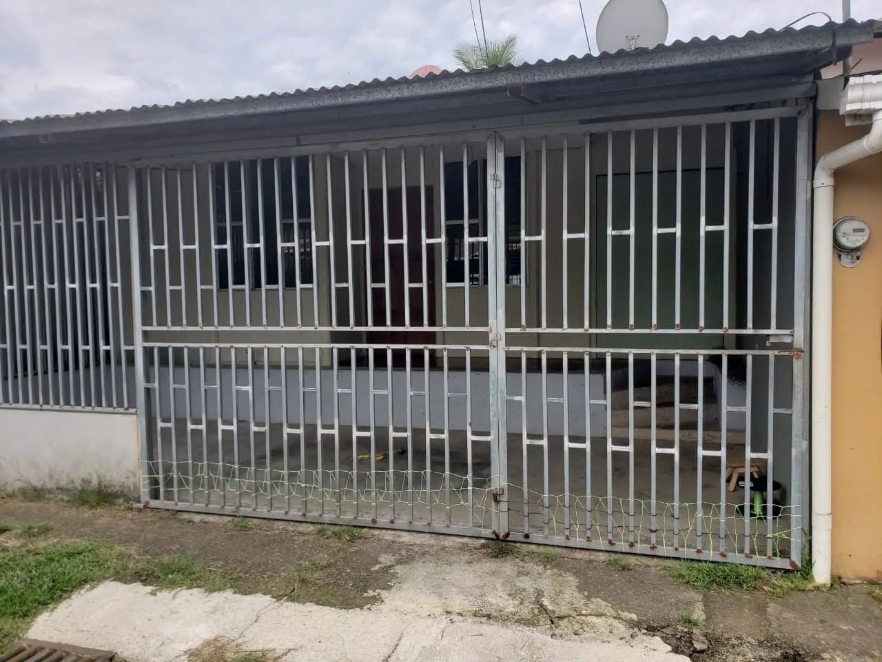 Frente de la casa con la verja cerrada