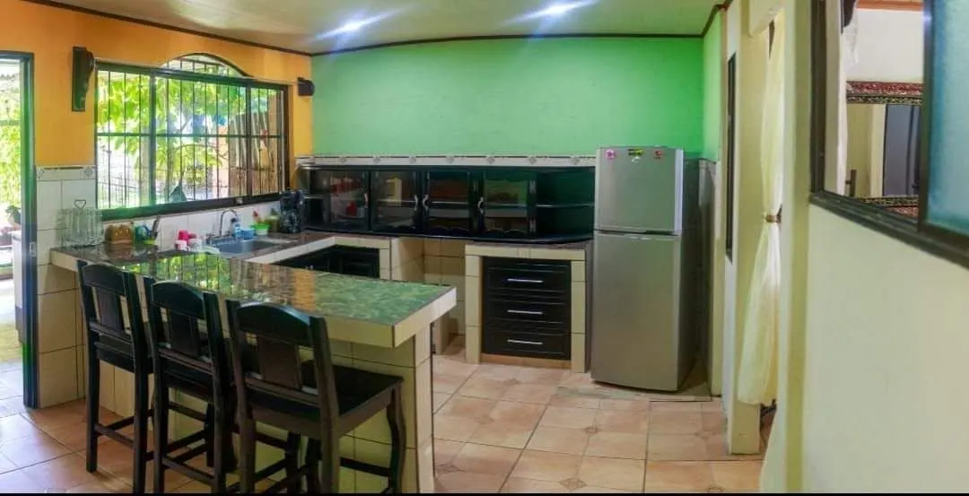 Cocina con pared verde y mueble de azulejo