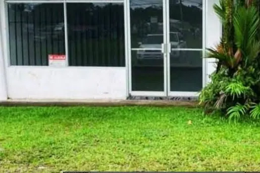 Local con vitrinas y puerta doble de vidrio frente al zacate