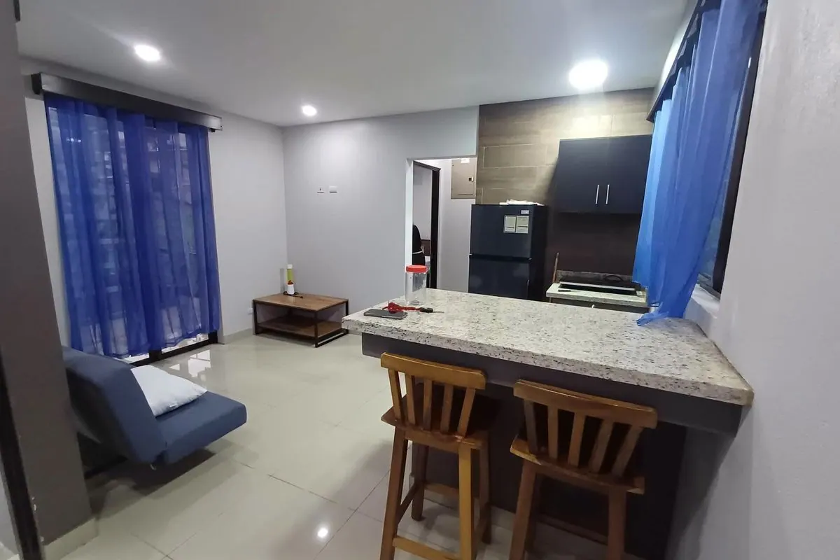 Sala con sofá cama y cocina con desayunador del apartamento amueblado en alquiler
